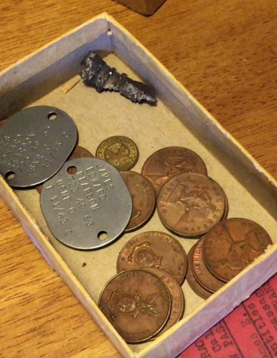 James Reardon keeps his dog tags from WWII, a piece of shrapnel he found on the deck of his ship, and money from WWII in a box.