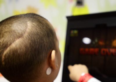 After a nap and eating snacks, Tae plays video games in the playroom at UH Rainbow while chemotherapy drugs are pumped into him.