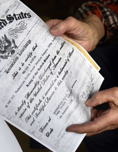 Walter Auxter holds a copy of his honorable discharge certificate.